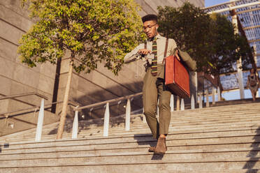 Businessman descending stairs of office building, Milano, Lombardia, Italy - CUF52168