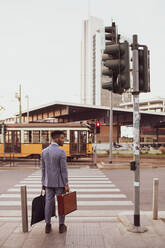 Geschäftsmann wartet am Fußgängerübergang, Mailand, Lombardei, Italien - CUF52179