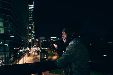 Businessman using smartphone on balcony, Milano, Lombardia, Italy - CUF52208