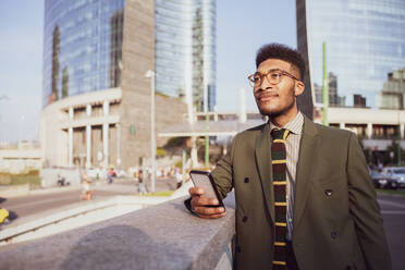 Businessman using smartphone on pavement, Milano, Lombardia, Italy - CUF52224