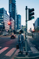 Geschäftsmann wartet am Fußgängerübergang, Mailand, Lombardei, Italien - CUF52241