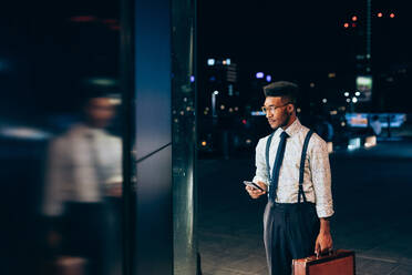 Businessman looking into window of shop - CUF52243