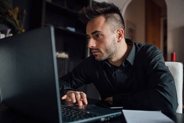 Mann benutzt Laptop im Heimbüro - CUF52257