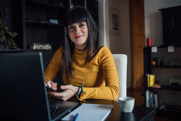 Frau benutzt Smartphone im Heimbüro - CUF52262