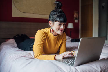 Frau mit Laptop auf dem Bett - CUF52269