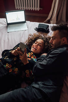 Ehepaar benutzt Smartphone auf dem Bett - CUF52277