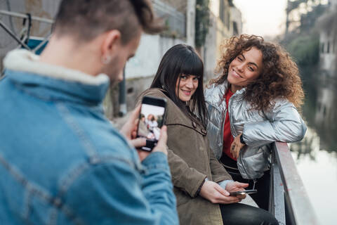 Freunde beim Fotografieren am Fluss, Mailand, Lombardei, Italien, lizenzfreies Stockfoto