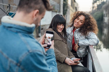 Freunde beim Fotografieren am Fluss, Mailand, Lombardei, Italien - CUF52286