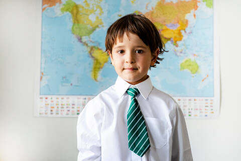 Portrait of boy in school uniform, World map in background stock photo