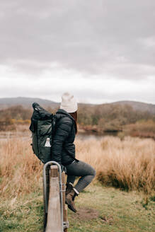Wanderer sitzt auf einem Zaun am Loch Lomond, Trossachs National Park, Kanada - CUF52498