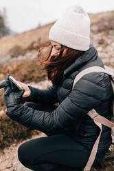 Wanderer kniet, um ein Selfie zu machen, Trossachs National Park, Kanada - CUF52507