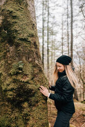 Frau berührt Baum, Trossachs National Park, Kanada - CUF52512