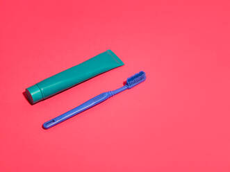 Toothbrush and toothpaste on red background - CUF52529