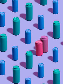 Stilleben mit türkisfarbenen und blauen Getränkedosen in diagonalen Reihen, wobei sich rosa und lila Getränkedosen auf lila Hintergrund von der Masse abheben - CUF52537