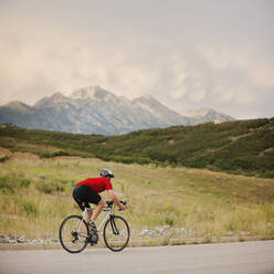 Caucasian man riding bicycle on remote road - BLEF07790