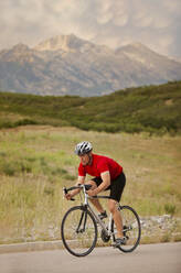 Caucasian man riding bicycle on remote road - BLEF07791