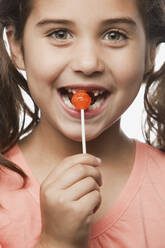 Mixed race girl eating lollipop - BLEF07818