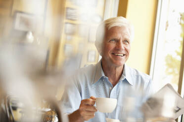 Caucasian man drinking coffee in restaurant - BLEF07895