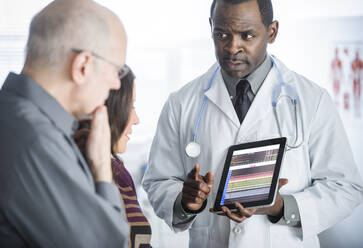 Doctor showing tablet computer to patients - BLEF07997