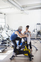 Older Hispanic man working with trainer in gym - BLEF08032