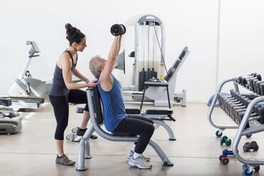 Older Hispanic man working with trainer in gym - BLEF08035