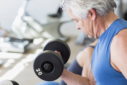 Älterer hispanischer Mann hebt Gewichte im Fitnessstudio - BLEF08038