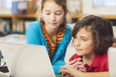 Kaukasische Kinder benutzen Laptop in der Bibliothek - BLEF08060