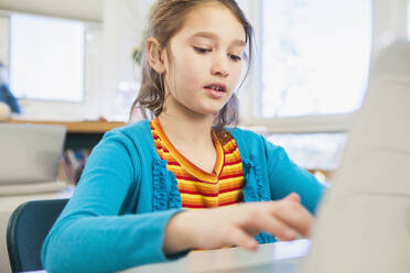 Kaukasisches Mädchen benutzt Laptop in der Bibliothek - BLEF08065