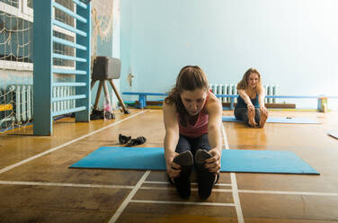 Caucasian dancers stretching in gym - BLEF08100