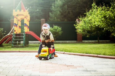 Caucasian boy playing with toy truck in playground - BLEF08114