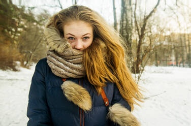 Kaukasische Frau mit Pelzkapuze und Mantel in einem verschneiten Feld - BLEF08123