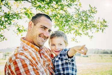 Vater und Sohn beim Zeigen auf dem Bauernhof - BLEF08173