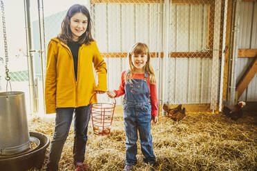 Kaukasische Schwestern sammeln Hühnereier im Stall - BLEF08212