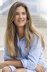 Portrait of young businesswoman, office building in the background - DIGF07103