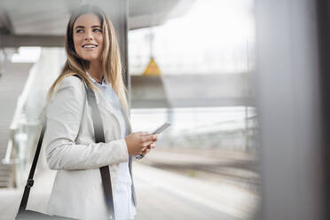 Young businesswoman using tablet standing on station - DIGF07141