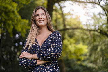 Smiling young woman in park - DIGF07159