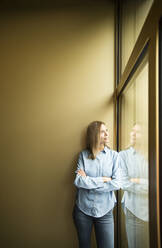 Businesswoman looking out of window - MFRF01340