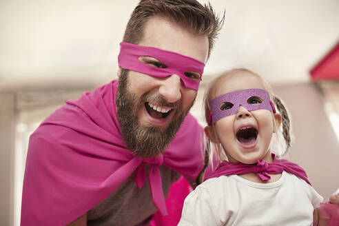 Father and daughter playing superhero and superwoman - ZEDF02489