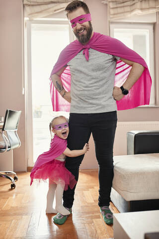 Vater und Tochter spielen Superheld und Superfrau, lizenzfreies Stockfoto
