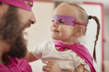 Father and daughter playing super hero and superwoman - ZEDF02509