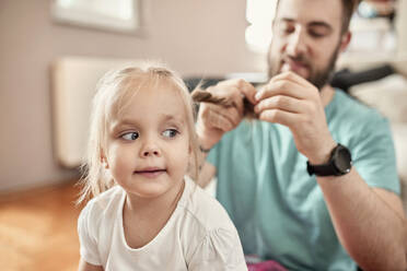 Father braiding hair of his daughter - ZEDF02513