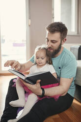 Vater und Tochter lesen ein Buch - ZEDF02514