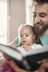 Vater und Tochter lesen ein Buch - ZEDF02515