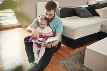 Vater und Tochter lesen ein Buch - ZEDF02516