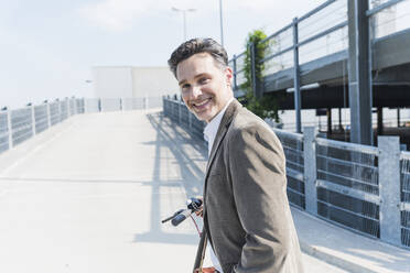 Smiling businessman with E-Scooter - UUF18154