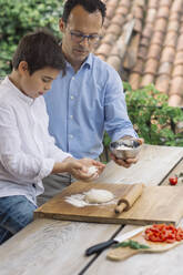 Father and son preparing pizza together - ALBF00911