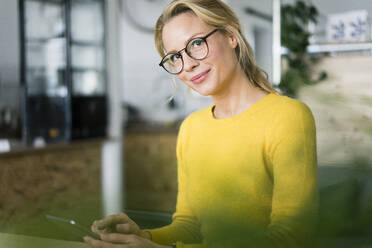 Hübsche Frau in einem Café, die ein Mobiltelefon benutzt - JOSF03329