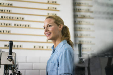 Blond woman working at the counter of a coffee shop - JOSF03352