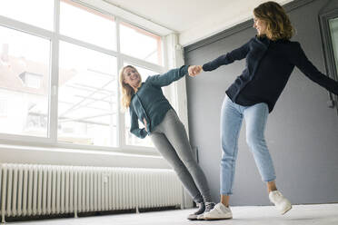 Zwei junge Frauen, die sich gegenseitig spielerisch unterstützen - JOSF03376