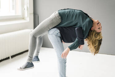 Zwei junge Frauen, die sich gegenseitig spielerisch unterstützen - JOSF03396